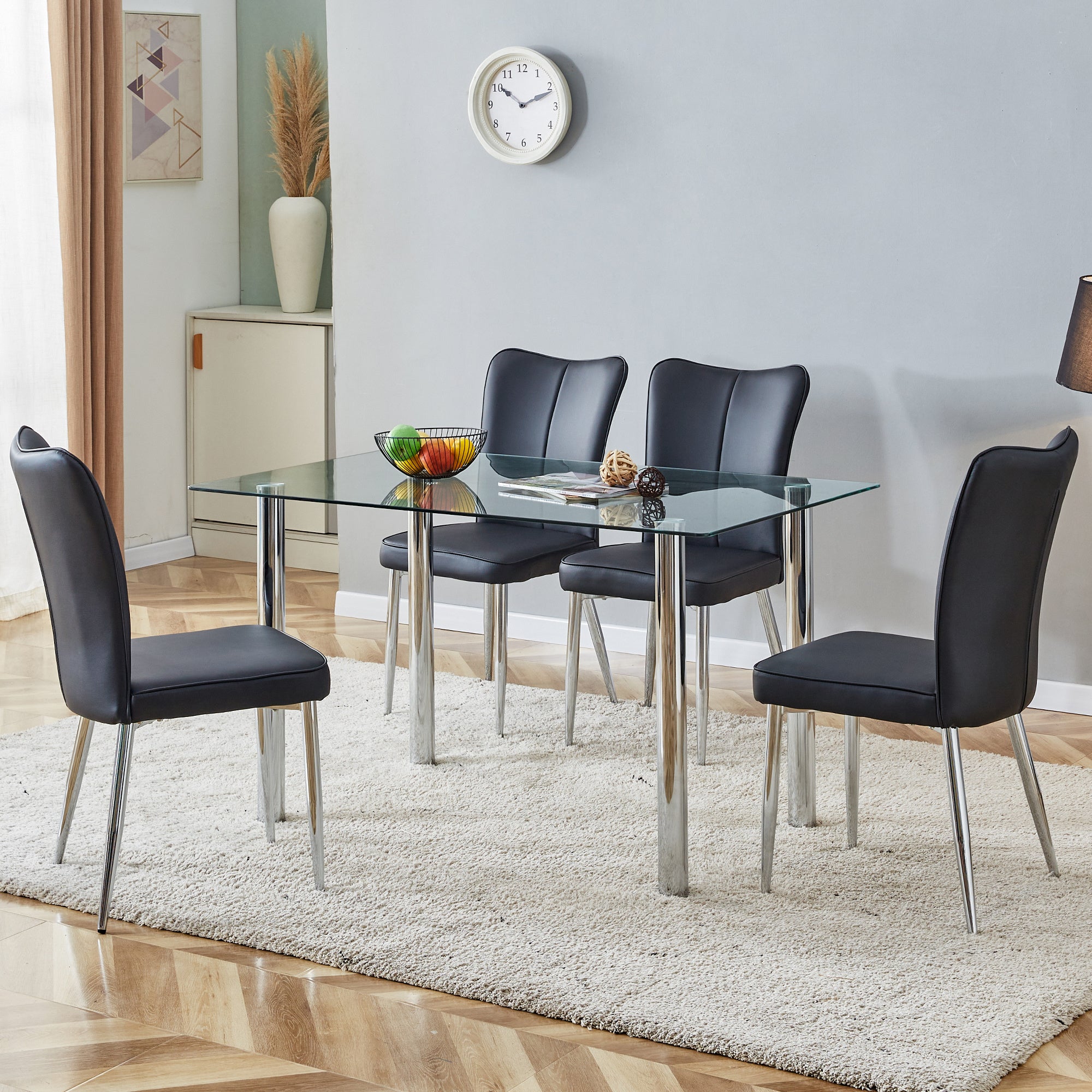 Table and chair set. 1 table and 4 black chairs. The thickness of the glass dining table top is 0.3 feet, with silver metal legs. Black PU leather backrest and seat cushion, electroplated metal chair