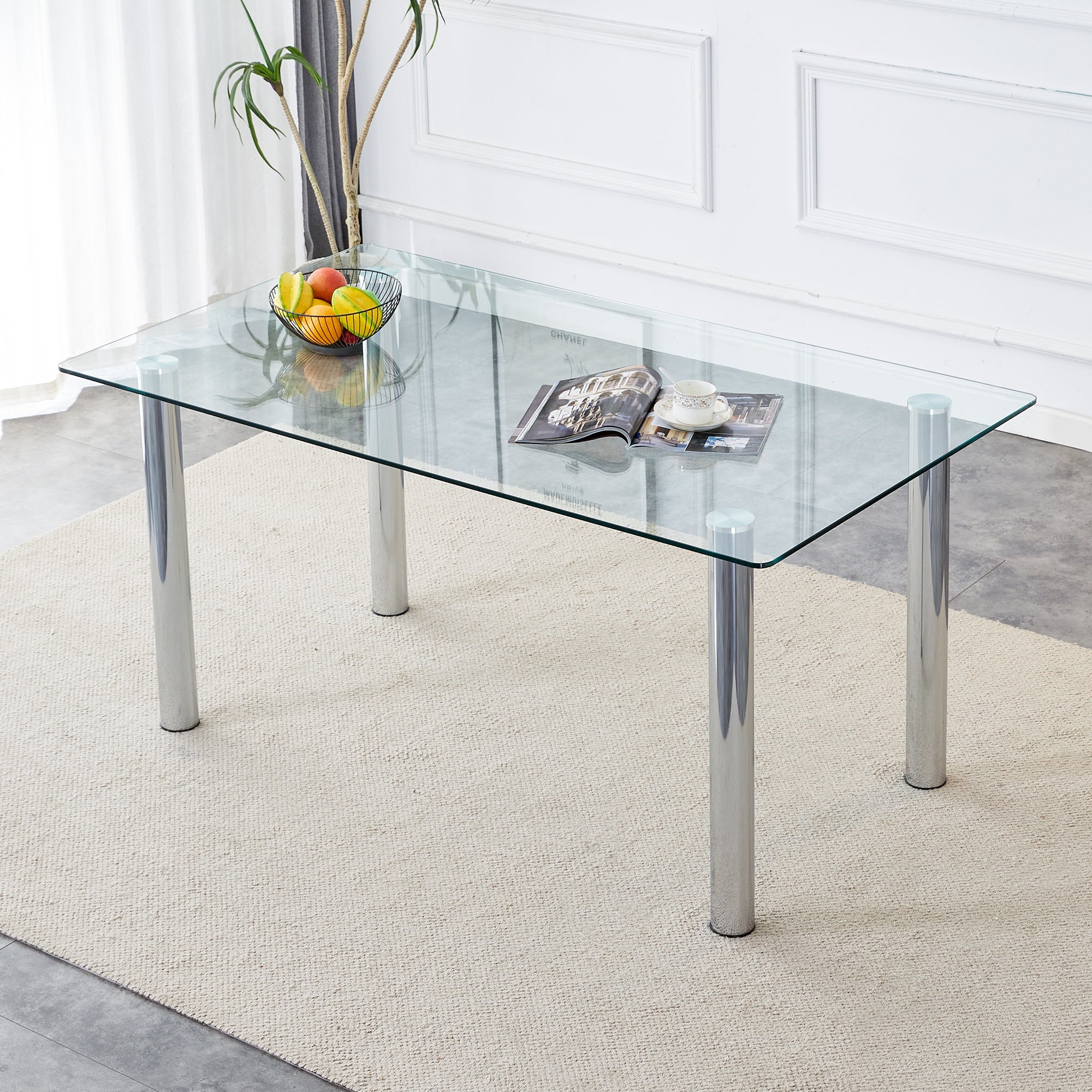 A modern minimalist style glass dining table. Transparent tempered glass tabletop with a thickness of 0.3 feet and silver metal legs. Suitable for restaurants and living rooms. 63 "* 35.4" * 30"