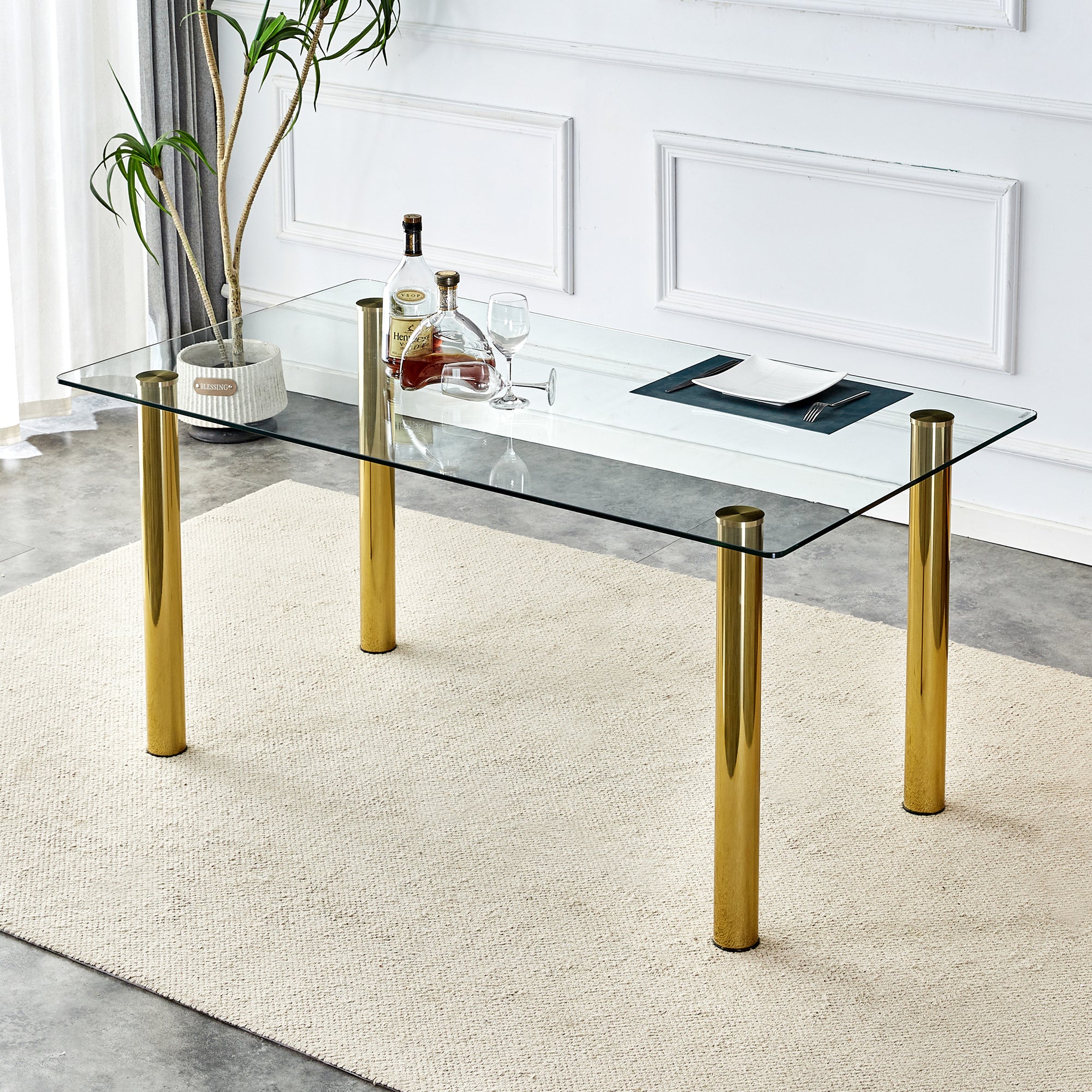 A modern minimalist style glass dining table. Transparent tempered glass tabletop with a thickness of 0.3 feet and golden metal legs. Suitable for restaurants and living rooms. 63"*35.4"*30"