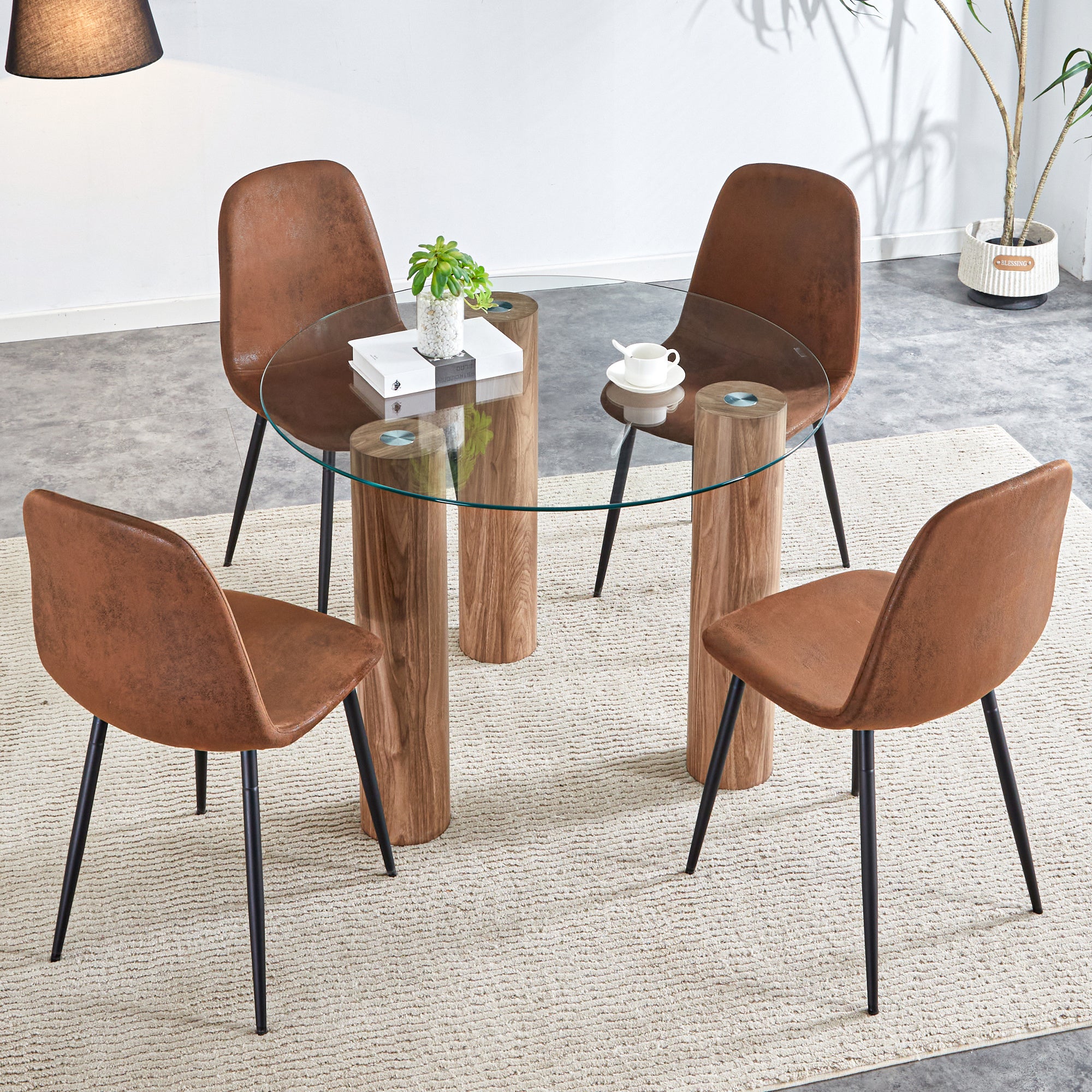 A modern and practical circular dining table. Made of transparent glass tabletop and wooden MDF table legs. A set of 4 brown cushioned chairs. F-X03 B0501A