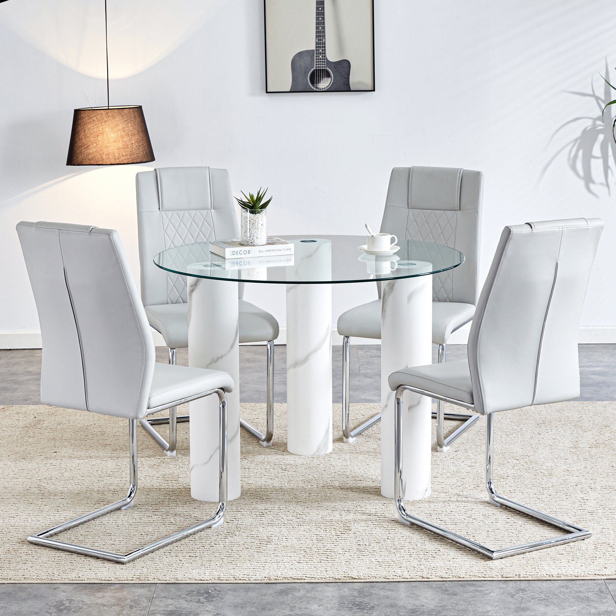 A modern minimalist circular dining table suitable for 6-8 people, paired with 4 light gray PU leather cushioned chairs and silver metal legs. F-X03 C-001