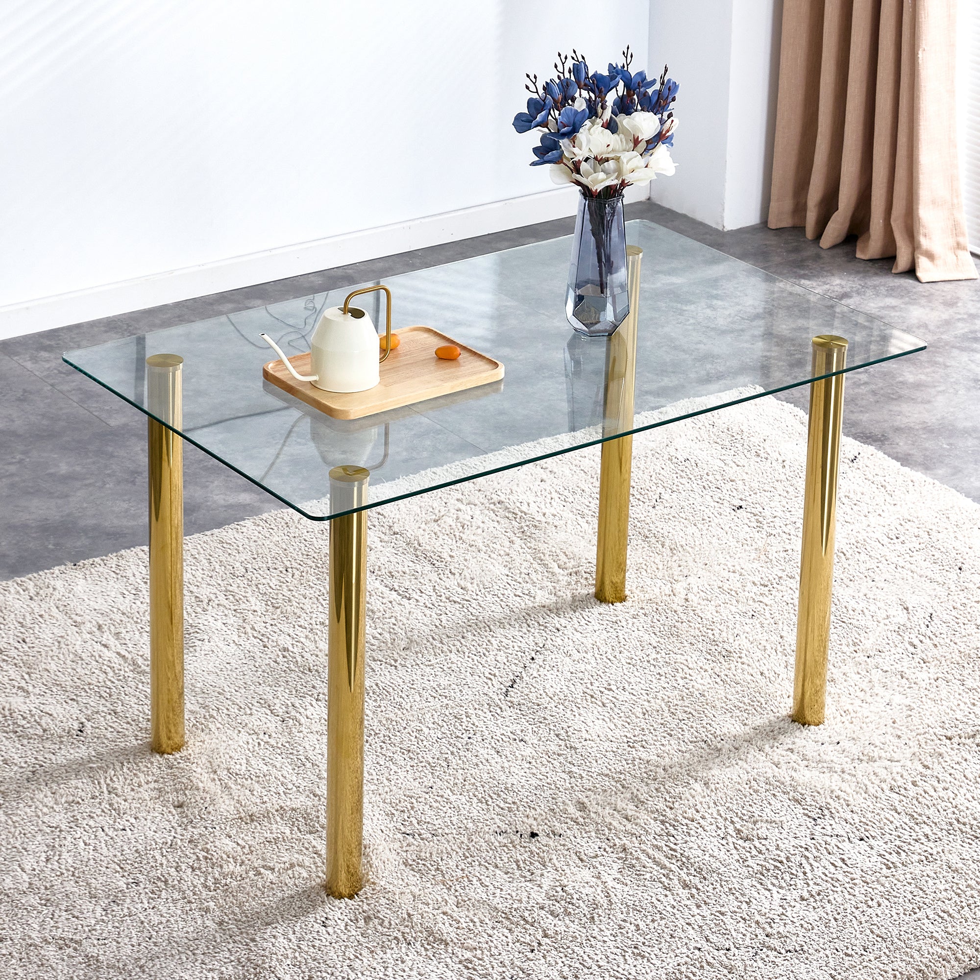 A modern minimalist style glass dining table. Transparent tempered glass tabletop with a thickness of 0.3 feet and golden metal legs. Suitable for restaurants and living rooms. 51"*31.4"*29.5"