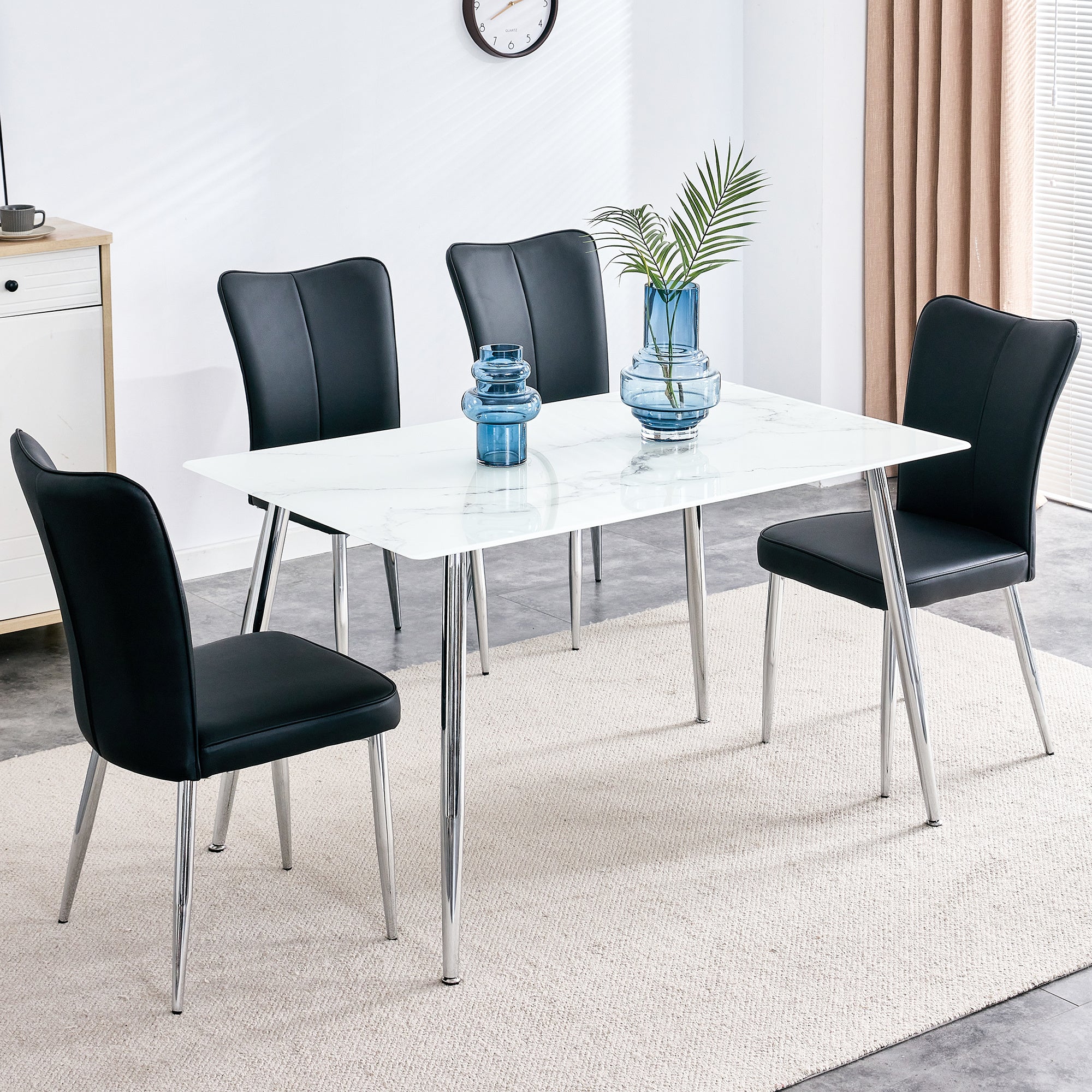 Table and chair set. 1 table with 4 black PU chairs. Modern minimalist rectangular white imitation marble dining table, 0.3 inches thick, with silver metal legs. Paired with 4 PU chairs DT-1544 008